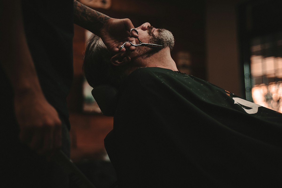 Barbero cortando el cabello a un cliente regular en una barbería de Puerto Rico